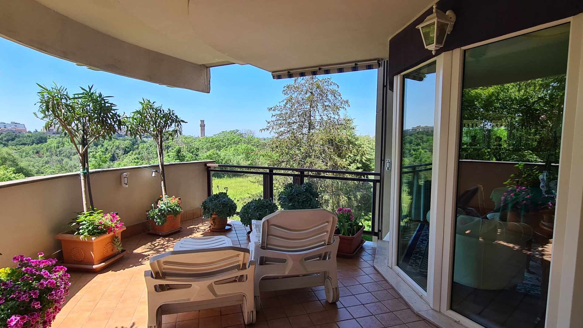 Grandi infissi scorrevoli bianchi che si affacciano su un terrazzo panoramico a Roma