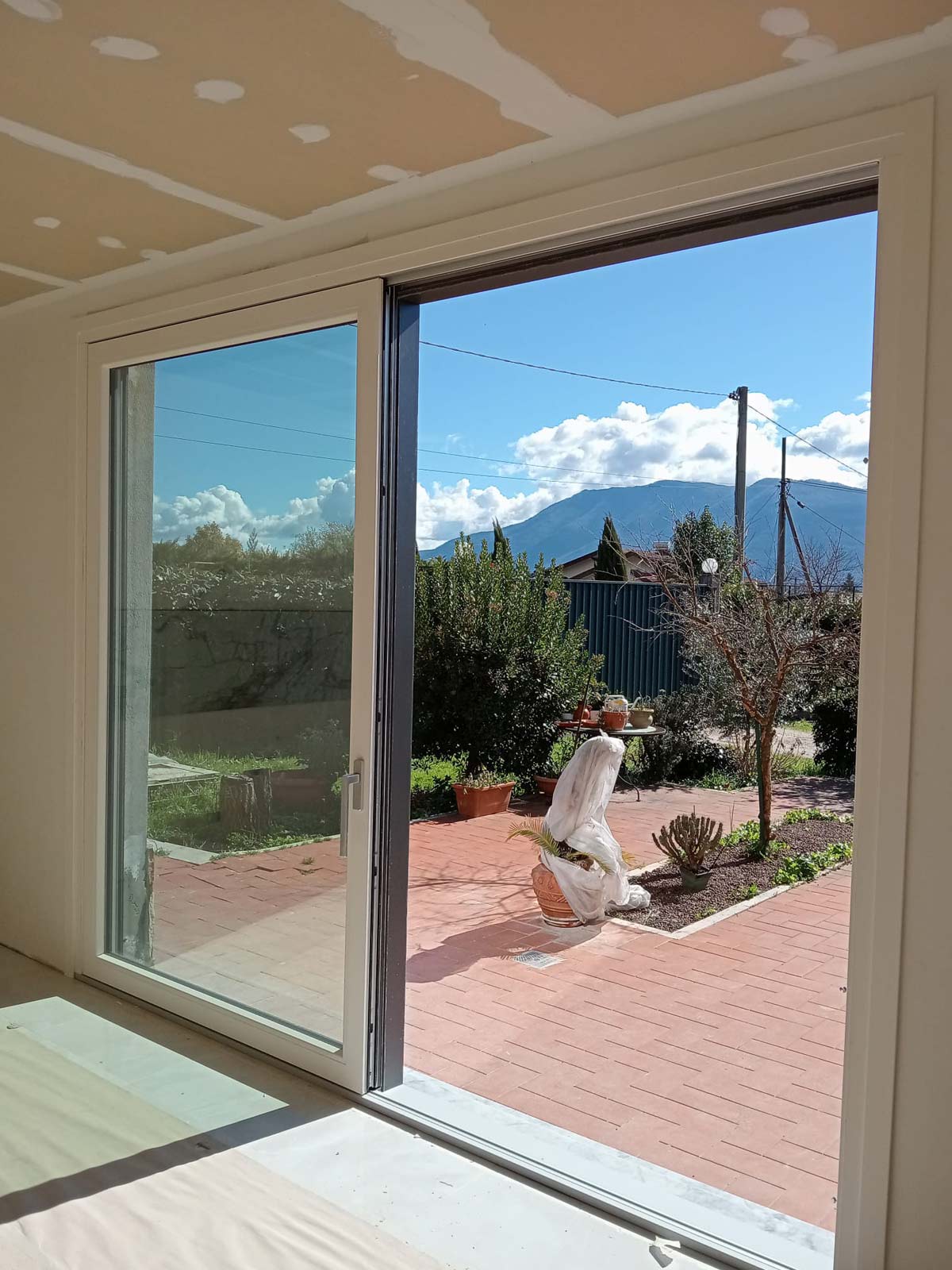 Dettaglio dell'infisso scorrevole in PVC con profilo bianco interno e grigio scuro esterno