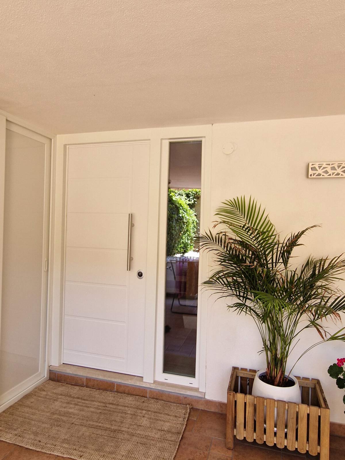 Ingresso con porta blindata bianca su misura e pannello laterale in vetro per luce naturale